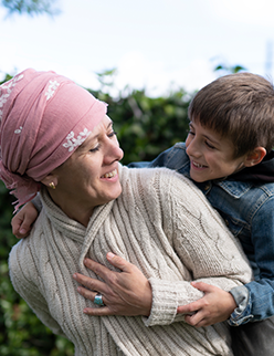 Woman in pink headscarf smiling with son