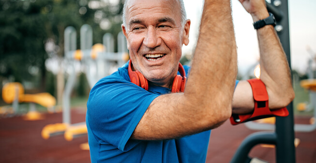 Smiling man using outdoor gym equipment