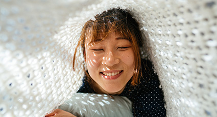 Woman smiling under blanket
