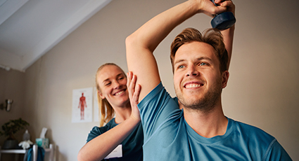 Man getting physiotherapy with weight above his head