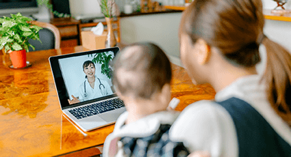 Young mum and baby on a video call with a GP