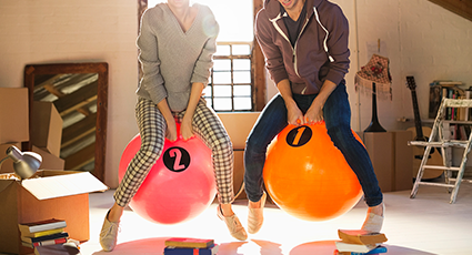 Two adults bouncing on bouncy hoppers